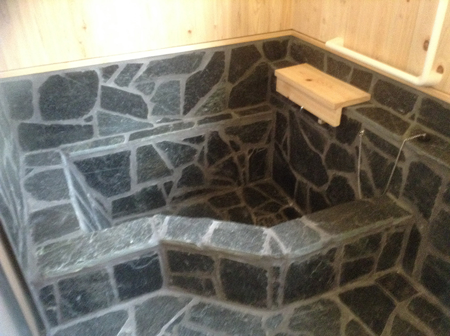 檜とシックな石貼りの浴室